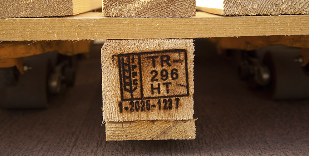 Sello de certificación fitosanitaria ISPM 15 pirograbado en la madera de un palé, indicando tratamiento térmico (HT) y origen en Turquía.