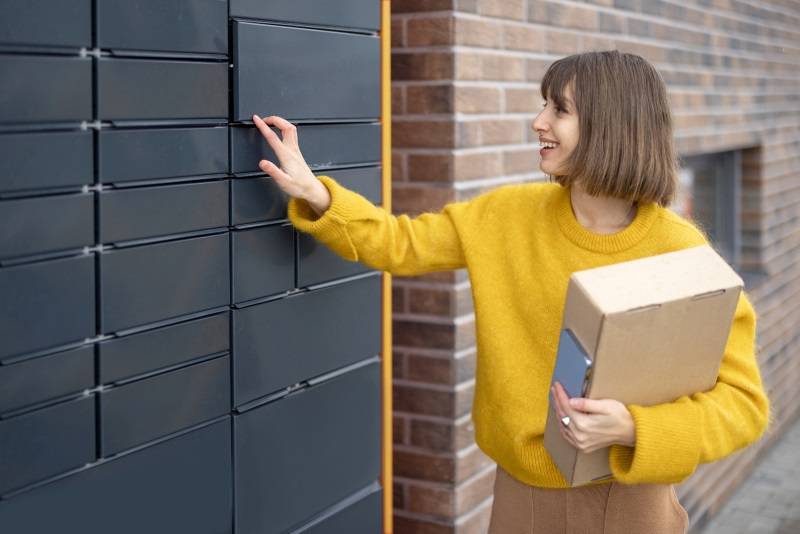 Mujer recogiendo un paquete en una taquilla de Micro-Hub urbano