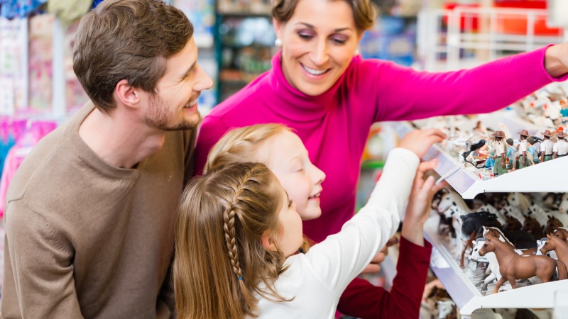 Adultos y niños eligiendo juguetes en una juguetería