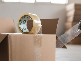 Cierre de cajas de embalaje con cinta adhesiva de alta resistencia para envíos de negocios.