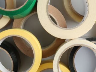 Rolls of different adhesive tapes on white background, flat lay